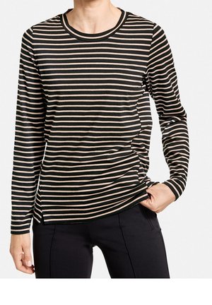 Schwarz-beige gestreifte Langarmbluse mit rundem Ausschnitt und Seiten Schlitzen. Weicher Stoff mit lockerer Passform, kombiniert mit dunklen Hosen.