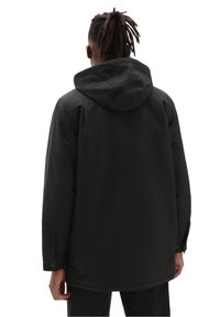 Giacca nera con cappuccio, dal taglio dritto, caratterizzata da una finitura opaca liscia e dettagli con bottoni ai polsini. Cuciture visibili.