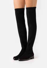 Svarta över knäboots i mocka, med en mjuk yta, rund tå och låg blockklack.