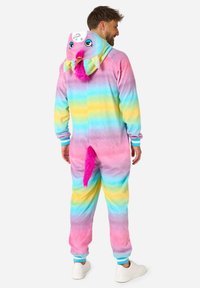 Rainbow-striped onesie in soft fabric with pink, blue, and yellow hues. Features a playful animal face on the hood and a faux fur tail.