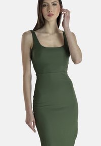 Abito bodycon a coste verde oliva con scollatura quadrata e silhouette aderente, realizzato in tessuto elasticizzato. Nessun motivo o dettaglio visibile.