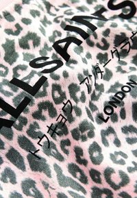 Tyg med rosa och grå leopardmönster, med svart text "L.L.S.A.M.S," japanska tecken och "LONDON."