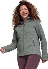 Graue Fleecejacke mit Kapuze, ausgestattet mit einem vollständigen Reißverschluss und seitlichen Taschen. Glatte Textur und lockere Passform, kombiniert mit dunkelvioletten Hosen.