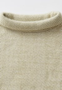 Beige gebreide trui met een textuurpatroon en een col. Zacht, warm materiaal met een lichte glans, dat een dicht geweven ontwerp laat zien.