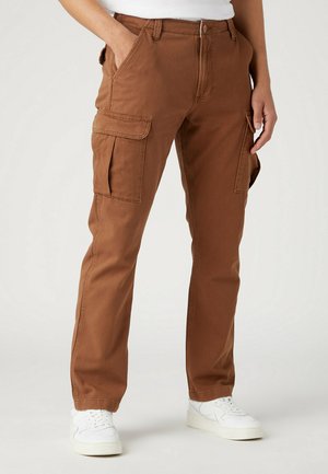 Pantaloni cargo marroni in cotone, con due tasche laterali, vestibilità dritta e un tessuto texturizzato. Abbinati a scarpe da ginnastica bianche.