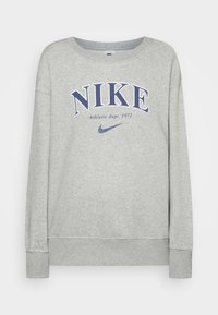 Grå sweatshirt i mjukt bomull med lös passform. Har "NIKE" i mörkblått och texten "Athletic dept. 1972" ovanför logotypen.