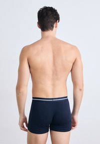 Navy blue boxer briefs with a fitted design, made of soft fabric, featuring a contrast striped waistband. Back view, minimalist style.