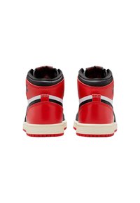 Un paio di sneakers alte in rosso, nero e bianco viste da dietro, che mostrano colli imbottiti e suole avorio.