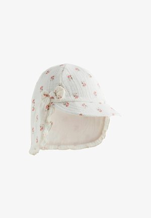 White cotton cap with small pink floral pattern, soft texture, rounded shape, front brim, and a ruffled edge with a fabric bow on the side.