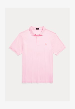 Pikétröja i ljusrosa, kortärmad, knappad krage, tillverkad av mjukt bomullstyg. Har en liten röd logotyp på bröstet.