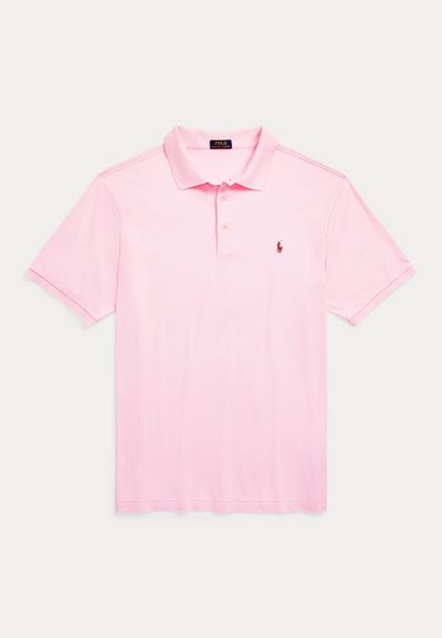 Šviesiai rožinė polo marškinėliai trumpomis rankovėmis, su sagotu apykakle, pagaminti iš lygaus medvilnės audinio. Krūtinėje matyti mažas raudonas logotipas.