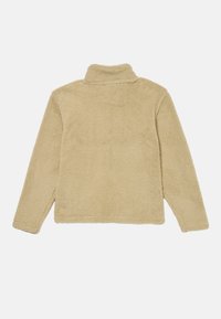 Giacca in fleece beige con colletto alto e maniche lunghe. Tessuto morbido, taglio dritto e cuciture visibili lungo i bordi. Vista posteriore.