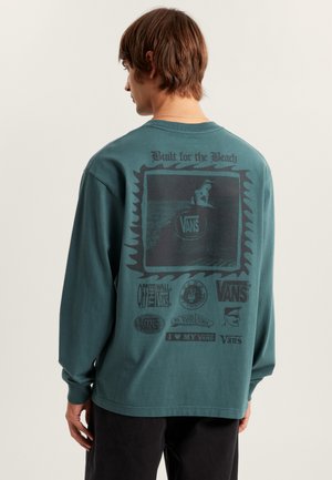 Langärmliges türkisfarbenes Shirt mit Grafikdruck, auf dem "Built for the Beach" und verschiedene Vans-Logos auf dem Rücken zu sehen sind. Baumwollmaterial mit lockerer Passform.