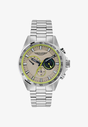 Ezüst színű krónográf óra bézs textúrájú számlappal, zöld kiegészítőkkel, tachyméteres kerettel és rozsdamentes acél karkötővel. Három segédszámlap található rajta.