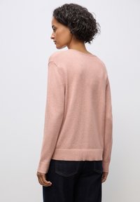 Maglione rosa con una texture morbida, vestibilità comoda, polsini e orlo rigati, con un'ampia scollatura e un design del retro liscio.