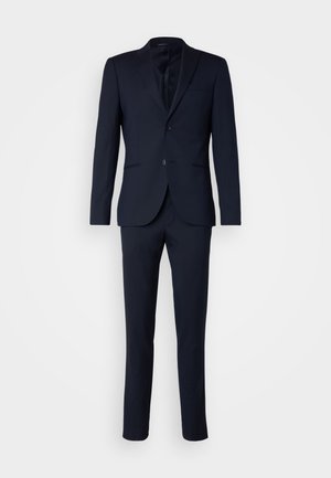 Costum deux piese de culoare bleumarin închis, cu sacou cu un singur nasture, având două butoane și pantaloni asortați, pe un fundal alb.