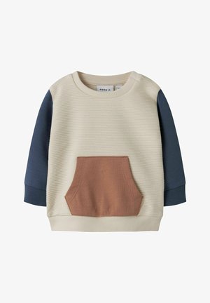 Pull en maille côtelée crème pour enfant avec manches longues bleu marine et une poche avant marron au centre.