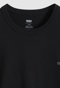 Μαύρο βαμβακερό μπλουζάκι με στρογγυλή λαιμόκοψη, άνετη εφαρμογή και μινιμαλιστικό λογότυπο Levi's στο μπροστινό μέρος. Διαθέτει λεία υφή και ραμμένες άκρες.