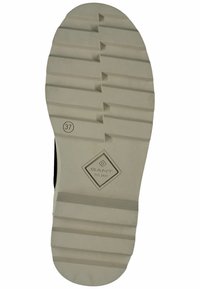 Rubber shoe sole with a white base, featuring a ridged texture, engraved logo, and size marking "37." Triangular pattern accents for traction.