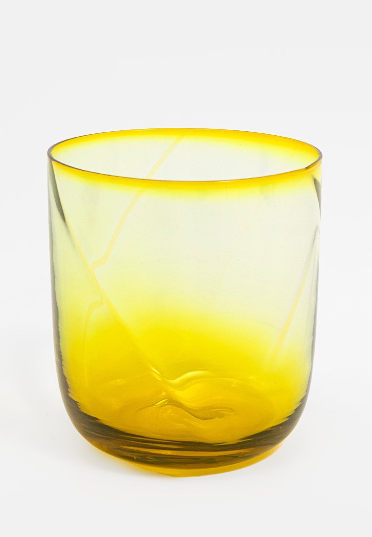 Vaso de cristal transparente con un degradado amarillo, que presenta curvas suaves y sutiles remolinos, creando una apariencia texturizada.