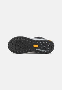 Svart og grå utendørssåle med teksturert gummi, med et fremtredende Vibram-logo og et mønster for multidireksjonal trekk.