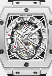 Zegarek ze stali nierdzewnej w kolorze srebrnym z designem szkieletem, czarnymi akcentami i gumowym paskiem. Posiada znaczniki godzinowe oraz czerwone i białe Detale.