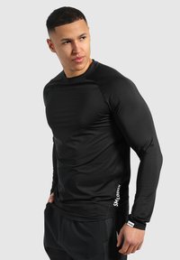 Schwarzes langärmliges Sportshirt mit einem enganliegenden Design, glatter Textur und Logodetail an der Seite. Geeignet für Sport und Training.