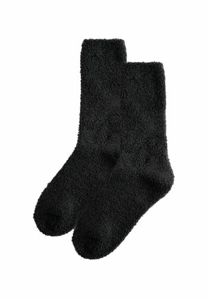 Black, fuzzy socks with a soft texture, featuring a classic shape and ribbed ankle. Designed for comfort and warmth.
