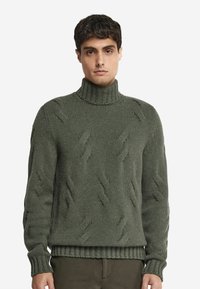 Grön stickad höghalssweater med ett texturerat mönster med upphöjda diagonala linjer samt ribbade ärmslut och nederkant.