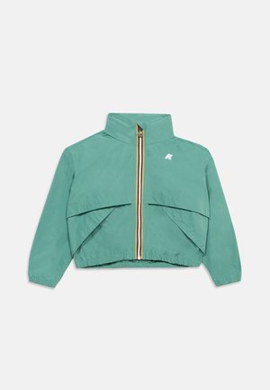 Tyrkysová zkrácená bunda s vysokým límcem, předním zipem s vícebarevným lemováním, elastickými manžetami a spodním okrajem a logem na levé straně hrudi.