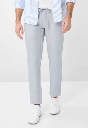 Light gray linen trousers with a relaxed fit, drawstring waist, and slightly cropped hems. Paired with white sneakers and a blue-striped shirt.