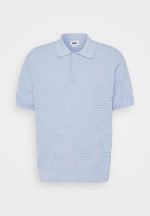 Polo bleu clair à manches courtes avec motif carré texturé, deux boutons, col côtelé et ourlet côtelé.