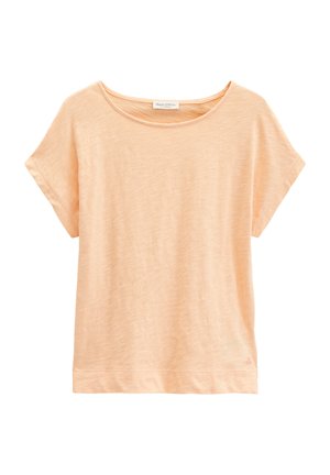 T-shirt ample à manches courtes couleur pêche clair, avec encolure ronde et petit logo sur l'ourlet en bas à gauche.