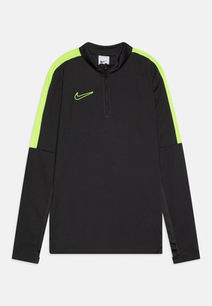 Maglietta da allenamento Nike nera con accenti verde brillante. Presenta un colletto alto, chiusura a mezzo zip e maniche lunghe con pannelli delle maniche a contrasto.