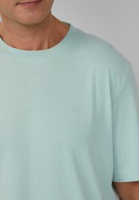 Helles blaues Baumwoll-T-Shirt mit Rundhalsausschnitt, kurzen Ärmeln und dezentem s.Oliver-Logo auf der Brust gestickt. Weicher Stoff, lockere Passform.