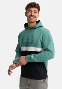 Felpa con cappuccio caratterizzata da blocchi di colore orizzontali turchesi, bianchi e blu navy; include un cordino regolabile e accenti in tessuto testurizzato.