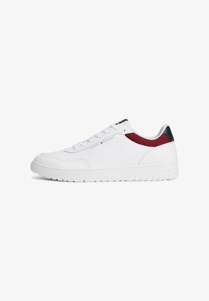 Zapatillas blancas hechas de material sintético. Presentan una superficie lisa, un acento textil rojo y una suela de goma con agarre texturizado.