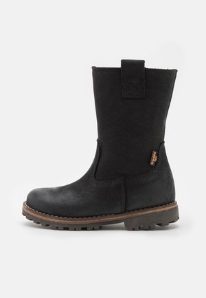 Botte en cuir noire mi-mollet avec languette de tirage, bord cousu marron, semelle robuste et petite étiquette de marque sur le côté.