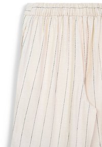 Pantalons cropped beige clair avec des rayures noires verticales, taille élastique et texture de tissu douce. Présente une silhouette large et décontractée.