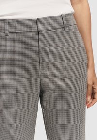 Broek in een houndstoothpatroon met grijze en zwarte tinten, gemaakt van een gestructureerde stof, met een recht model en zijzakken.