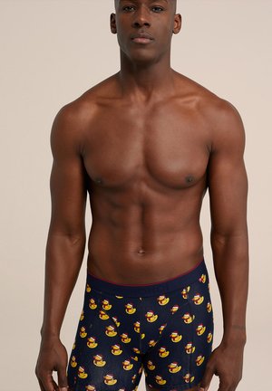 Vyriški bokseriai, pagaminti iš elastingos medžiagos, tamsiai mėlynos spalvos su guminiu ančiuku raštu. Savybės: raudonas juostos perimetras ir tvirtas prigludimas.