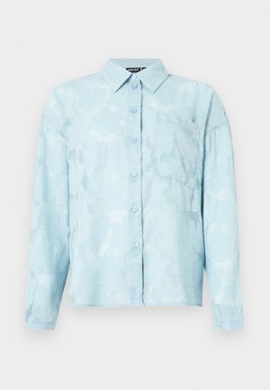 Cămașă cu un model floral de culoare bleu deschis, confecționată dintr-un material transparent, având guler, închidere cu nasturi și un buzunar pe piept. Mâneci lungi cu mansete.