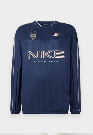 Námornícky modrá mikina s dlhým rukávom značky Nike s jemnými pruhmi, obsahujúca veľké biele logo, text "SINCE 1972" a vyšívaný emblém na ľavom prsníku.