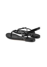 Zwarte platte sandalen met dunne, gevlochten bandjes met een zilveren accent. De zolen zijn slank en gemaakt van soepel rubbermateriaal.