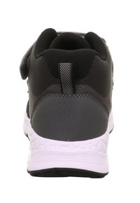 Schwarzer Sportschuh mit strukturiertem Synthetik-Obermaterial, gepolstertem Kragen und kontrastierender weißer Außensohle. Klettverschluss für einen sicheren Sitz.
