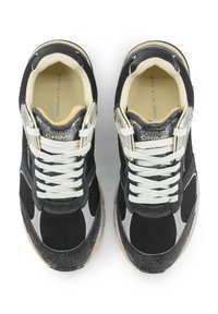 Sneakers nere con accenti grigi, textures in rete e pelle, lacci bianchi e suola marrone chiaro. Branding visibile sulla linguetta e sul lato.