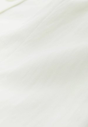 Close-up of white fabric showing soft texture and subtle folds.