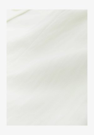 Close-up of white fabric showing soft texture and subtle folds.