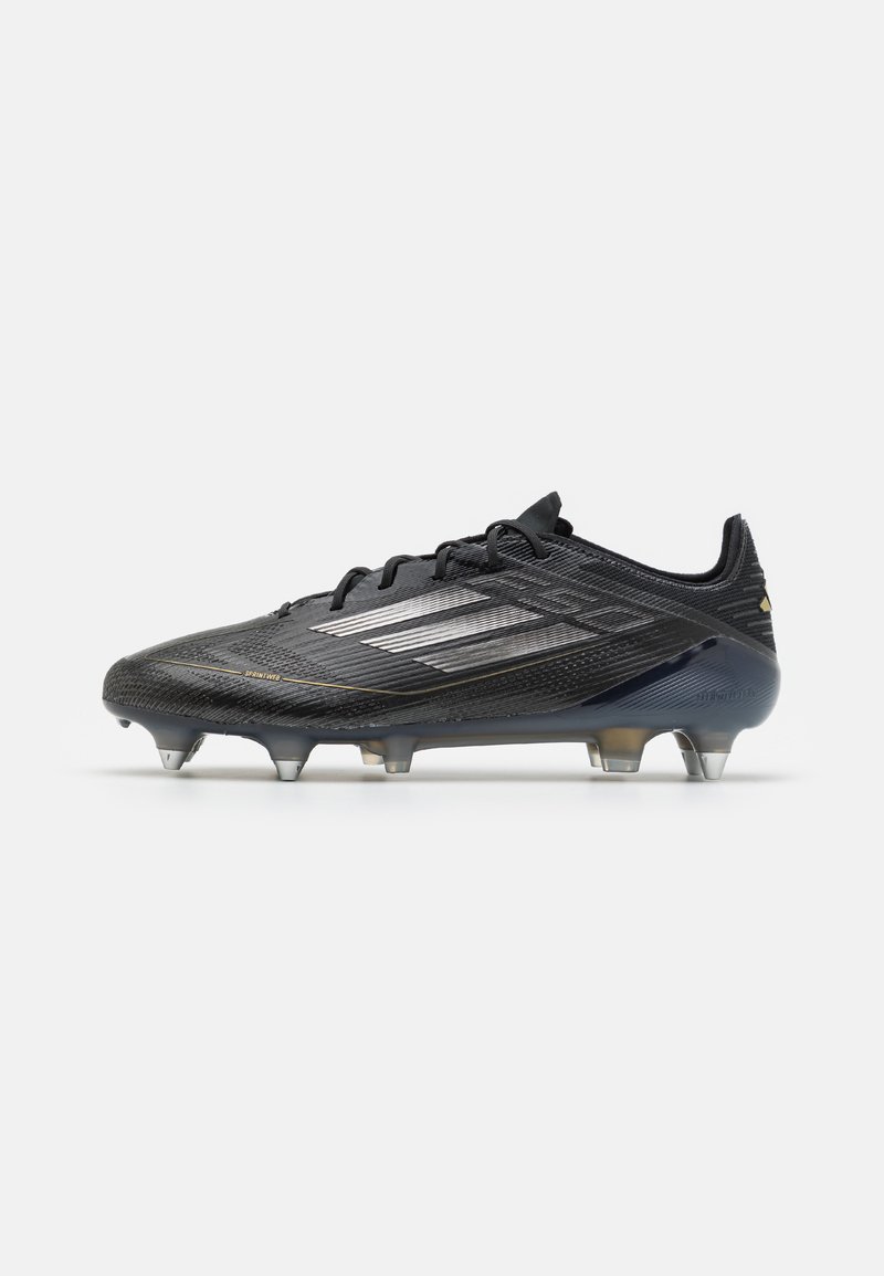 Black soccer cleat with a textured upper, silver accents, and a low profile. Features six conical studs for traction on grass surfaces.