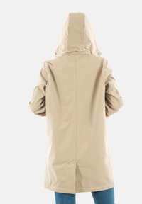 Abrigo impermeable beige con capucha, que presenta una textura suave y un corte recto. La vista trasera muestra una abertura en la parte inferior.